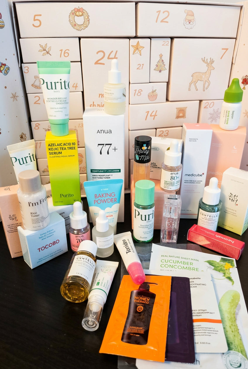 A collection of skincare products and packaging arranged on a dark surface in front of a decorated advent calendar box. Visible brands include Purito, Anua, and medicube advent calendar, korean skincare