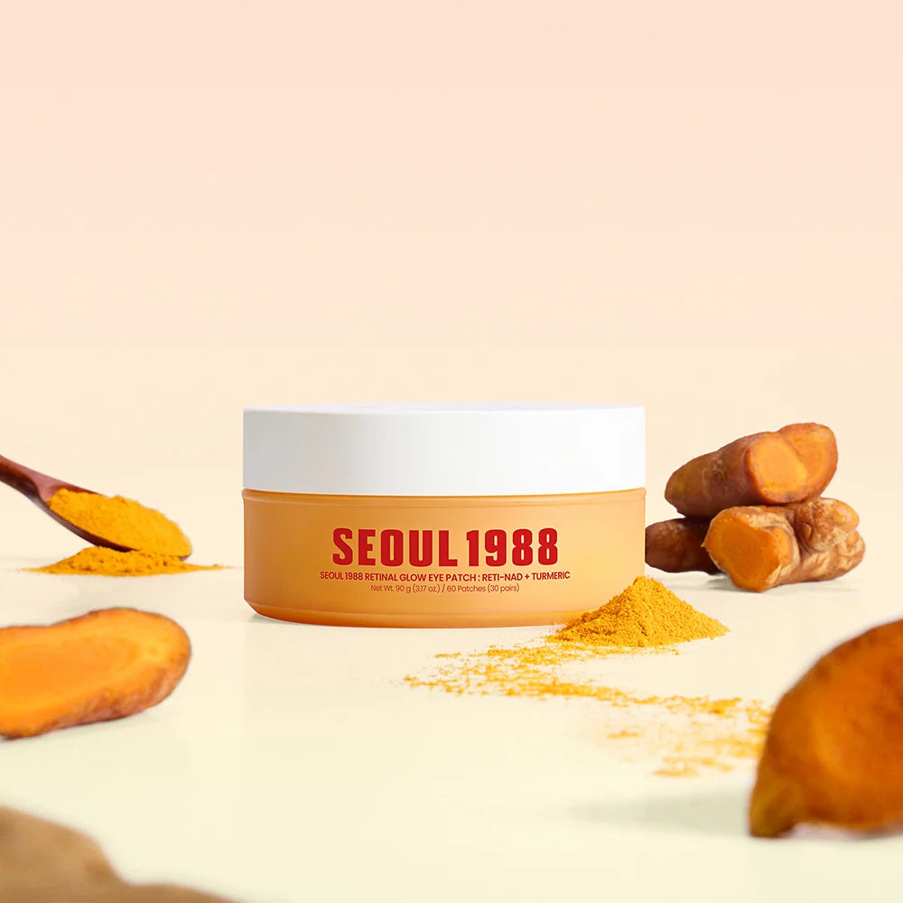 A jar of Seoul 1988 eye patch with patchouli and turmeric, styled with raw turmeric roots, powder, and a spoonful on a light beige background.