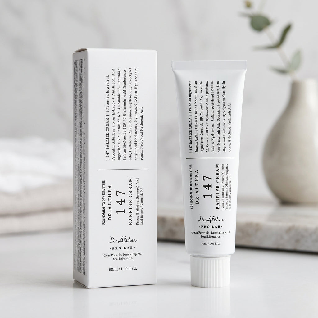 A white tube of Dr. Althea 147 Barrier Cream stands upright next to its matching white cardboard packaging box on a dark, reflective surface.